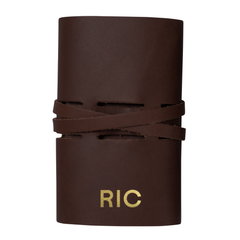 Chocolate leather tech accessory roll with silver hardware holding cables and chargers, personalized with initials