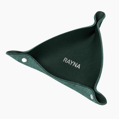 Emerald leather ring tray with snapped corners and a personalized monogram, holding rings and jewelry