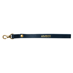 Navy leather wristlet strap with gold clasp, personalized with a stamped name